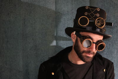 Portrait of young man wearing sunglasses against wall