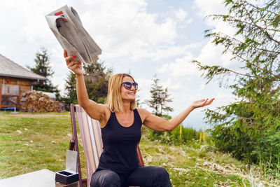 Full length of a young woman sitting against the sky