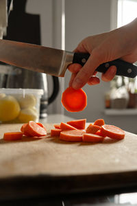 Cropped hand of person preparing food on cutting board