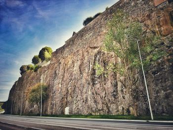 Road by rock formation against sky