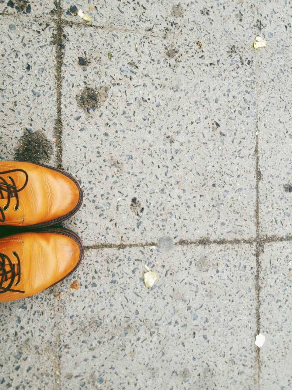 shoe, low section, footwear, person, high angle view, street, one person, pair, cobblestone, personal perspective, human foot, close-up, sidewalk, part of, directly above, yellow, outdoors, paving stone, day