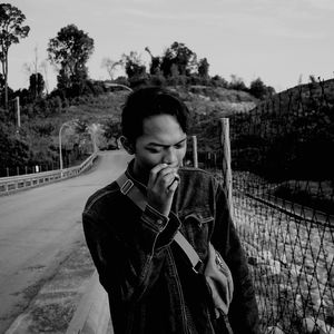 Man smoking by road