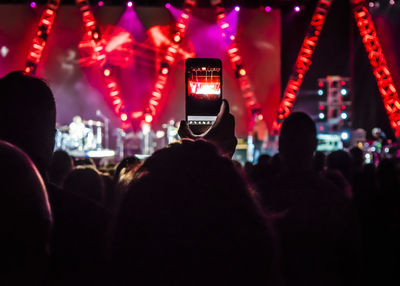 Woman photographing during music concert