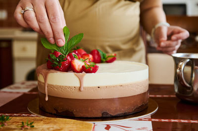 Midsection of woman holding drink on table