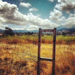 Scenic view of grassy field against cloudy sky