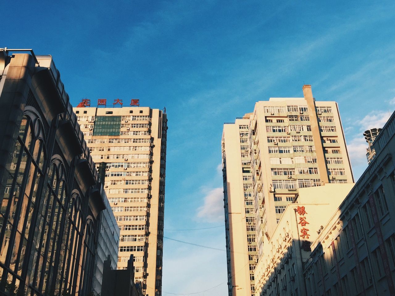 architecture, building exterior, built structure, low angle view, sky, city, building, blue, outdoors, no people, day, tall - high, city life, cloud, modern, cloud - sky, high section, information