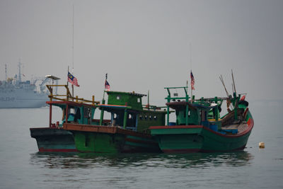 Boats in sea amidst fog