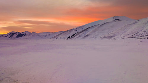 Scenic view of snowcapped mountain against sky during sunset