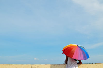 Rear view of woman on beach against sky