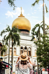 Rear view of woman against built structure