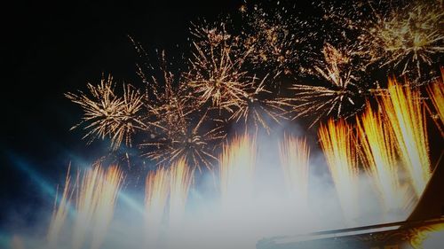 Low angle view of firework display against sky at night