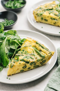 Healthy asparagus frittata meal with arugula salad closeup