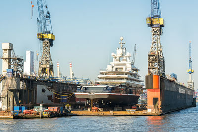 Yacht at dockyard against sky