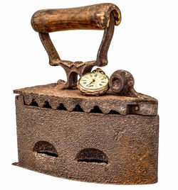 Close-up of rusty clock over white background