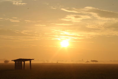 Scenic view of field against sky during sunset