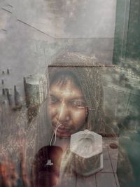 Digital composite image of woman with reflection on glass window