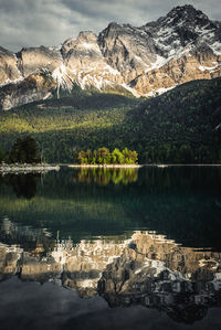 Beautiful alpine summer sunset at the lakeshore with reflections - eibsee lake in bavaria, germany