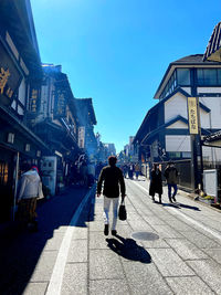 People walking on street in city against sky