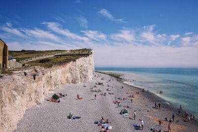 People on beach against blue sky