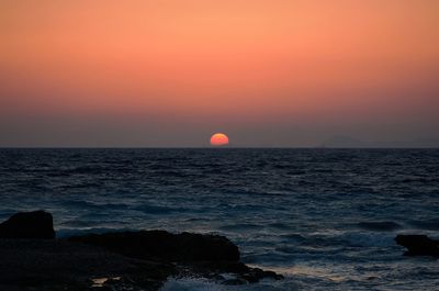 Scenic view of sea against orange sky