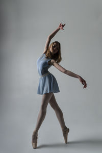 Ballet dancing against gray background