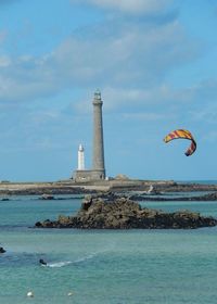 Lighthouse on shore against blue sky