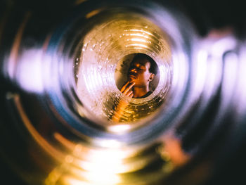 Young woman with eyes closed seen through bottle