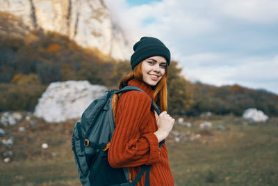 Portrait of smiling young woman standing in park during winter