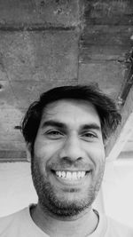 Portrait of smiling young man against wall