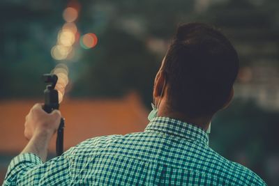 Rear view of man holding mobile phone