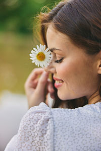 Close-up of girl blowing flower