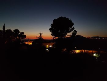 Silhouette trees against sky at night