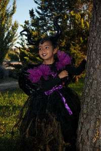 Portrait of smiling girl on tree trunk