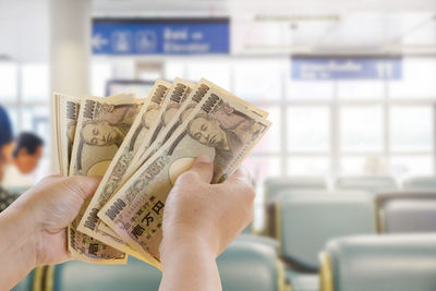 Cropped hands of money in airport