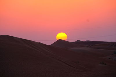 Scenic view of desert against sky during sunset