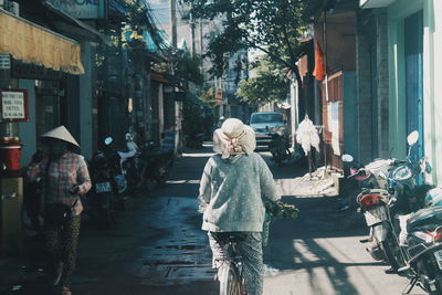 Rear view of woman walking on street in city