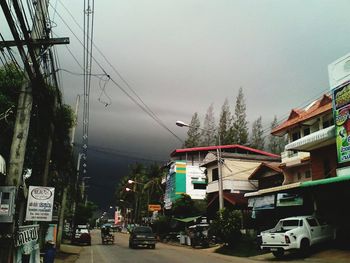 Cars on city street against sky