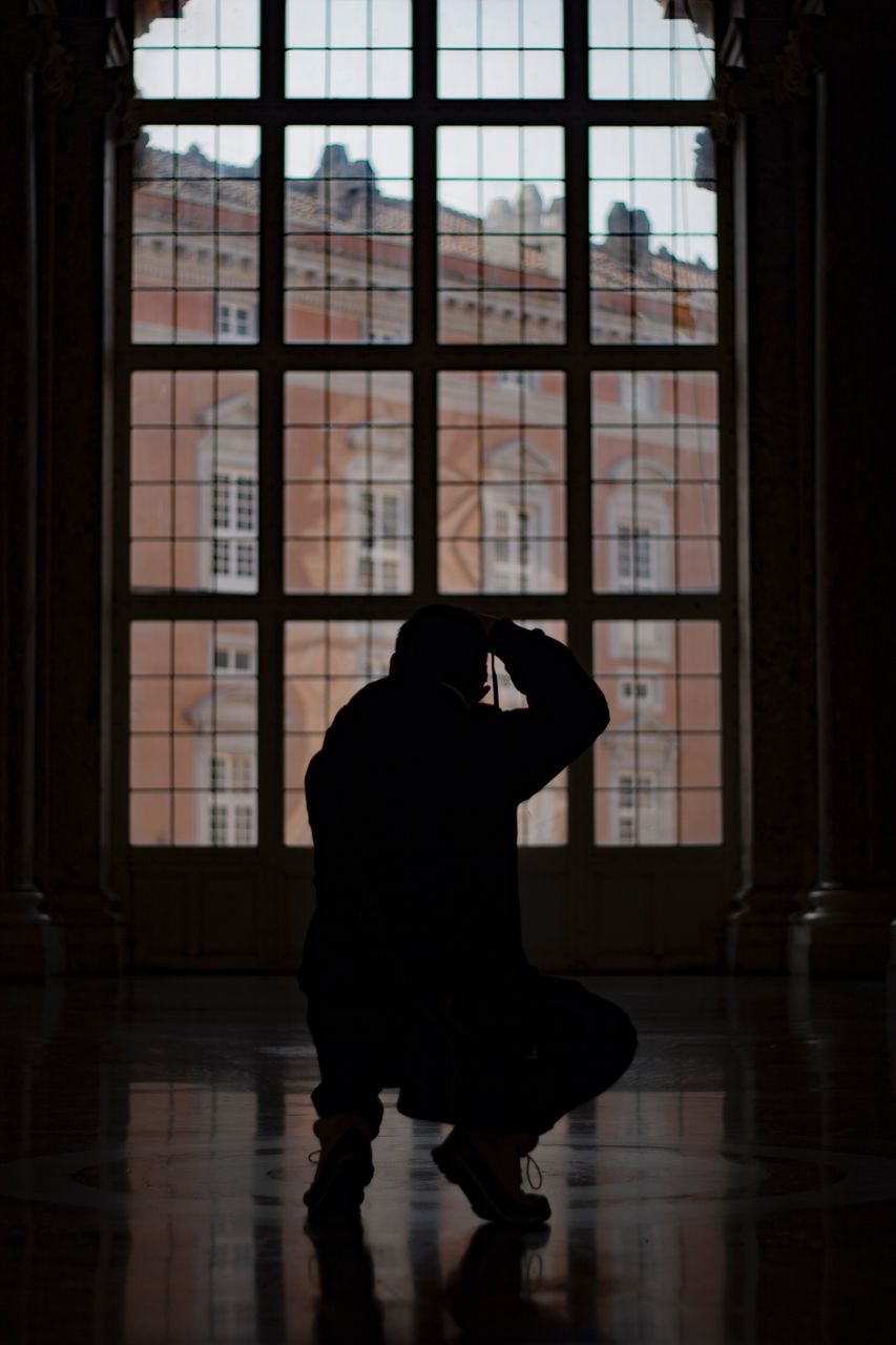 real people, window, indoors, silhouette, one person, full length, lifestyles, leisure activity, adult, women, flooring, day, glass - material, reflection, men, dancing, rear view, exercising