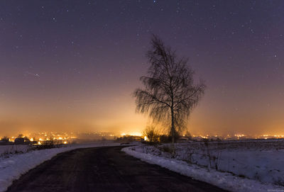 Snow covered field against sky at night