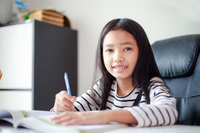 Portrait of smiling woman sitting at home