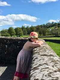 Portrait of girl leaning on retaining wall
