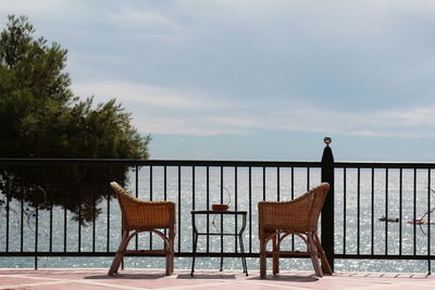 Two wicker chairs and a table for relaxing on the embankment with a view of the sea 