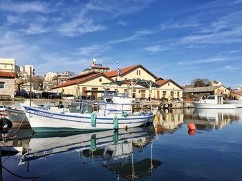 Boats moored in water against blue sky