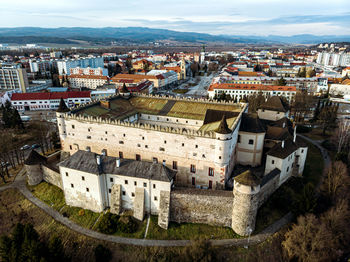 High angle view of a castle in city with buildings and sky