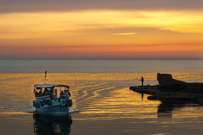 Silhouette boat in sea against sky during sunset