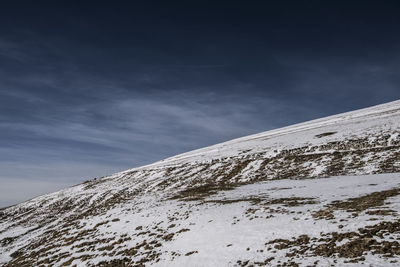 Low angle view of snowcapped mountain against sky