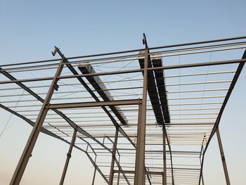 Low angle view of crane against clear blue sky