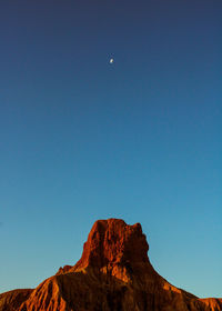 Low angle view of rock formation against clear blue sky