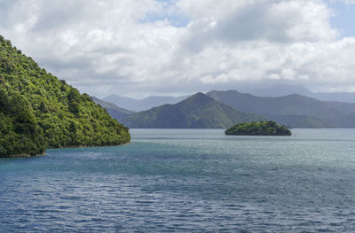 Scenic view of sea and mountains against sky