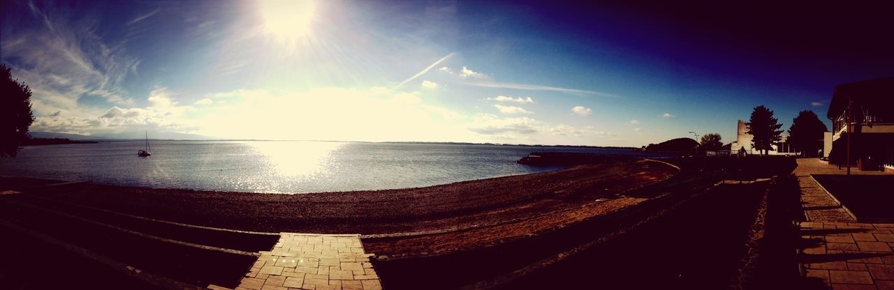 water, sea, sky, sunlight, horizon over water, sun, built structure, sunbeam, tranquility, tranquil scene, scenics, beach, sunset, nature, beauty in nature, cloud - sky, architecture, building exterior, shore, transportation